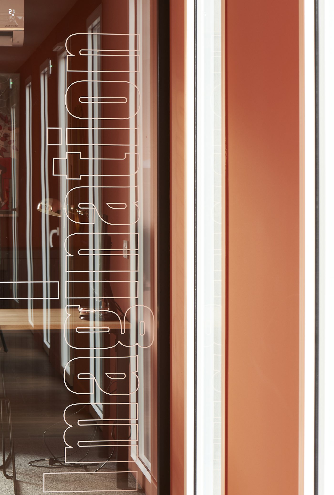 Bureau fermé Imagination au Vigean, nom gravé sur la porte vitrée, mur terracotta