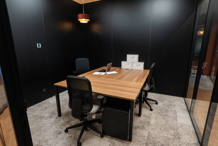 Bureau privatif de quatre postes, La Gravade, mur noir et table en bois