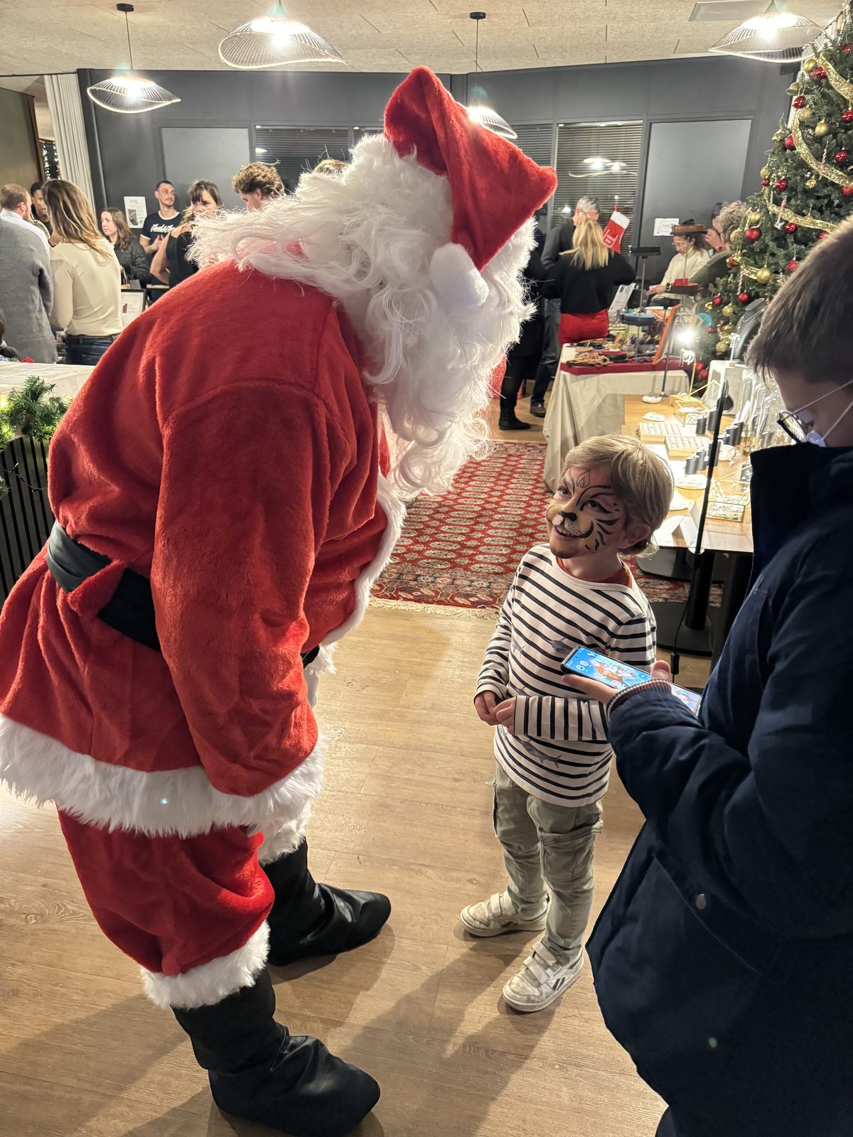 Père Noël et enfant lors d'un marché de Noël à La Gravade